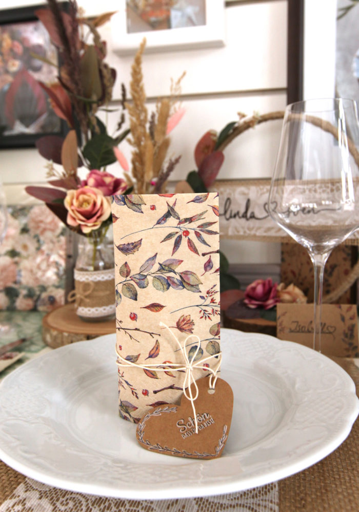 Ein herzförmiges Tischkärtchen wird von einer stehenden Serviette Colored Leaves begleitet. Die Gäste können kommen.