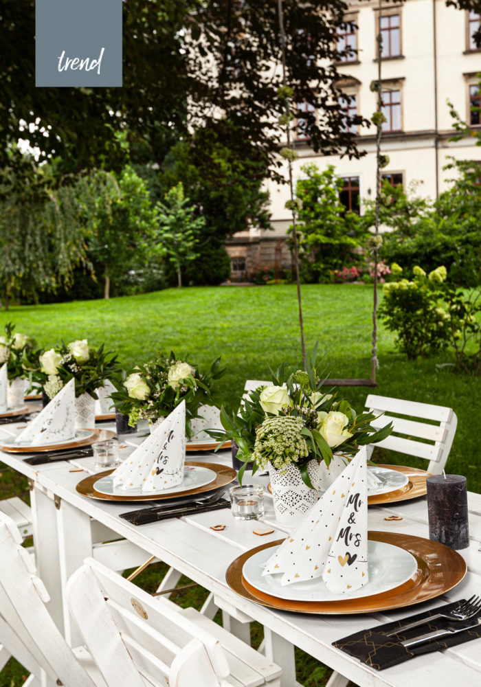 Alles ist bereit für die Hochzeit im Grünen. Der Gartentisch ist geschmückt mit frischen Blumen und den neuen Servietten Mr. und Mrs.