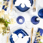 Eine weiße Serviette als Engel gestanzt und gefaltet, wirken auf den blauen Tellern besonderes elegant.