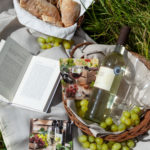 Ein Picknick im Grünen mit Baguette, Weintrauben, Wein und einem guten Buch. Was kann es schöneres geben?