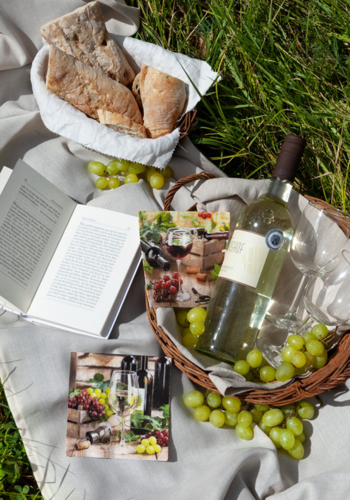 Ein Picknick im Grünen mit Baguette, Weintrauben, Wein und einem guten Buch. Was kann es schöneres geben?