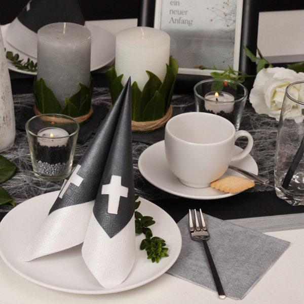 Der Tisch ist gedeckt für den Trauerkaffee. Die Tafel schmückt die Stanzserviette Punched Cross Pearl Effect black.