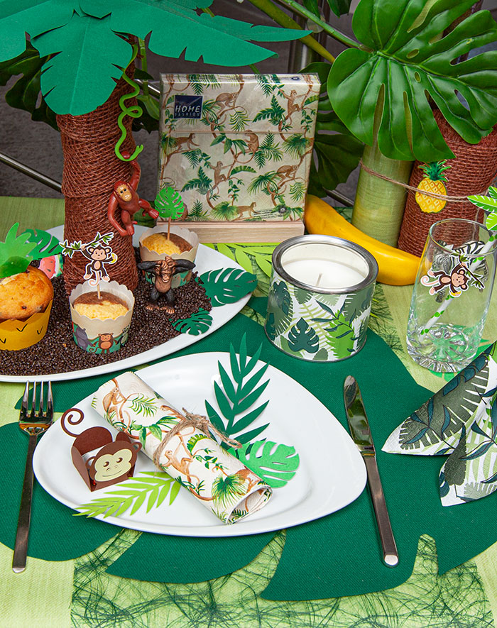 a table decoration in a jungle design. The napkins show climbing monkeys.